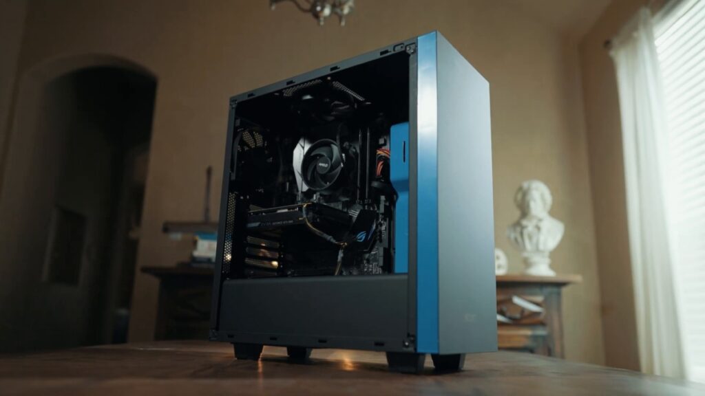 A sleek gaming PC with a blue panel and visible components, showcasing the internal hardware like a GPU and cooling fan.